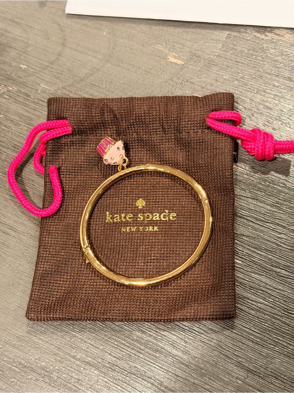 Kate Spade New York gold-toned bangle bracelet with a pink cupcake charm